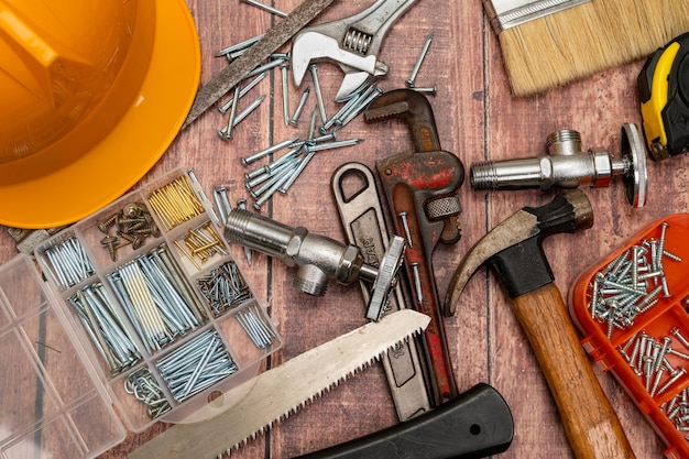 Photo on a wooden board a variety of tools needed for home repair are irregularly placed