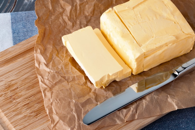 Wooden board with butter on blue checkered napkin