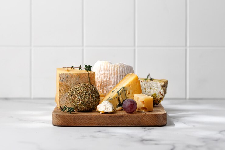Photo wooden board with cheeses and wine shropshire langre asiago gorgonzola shanklish cheese plate tile
