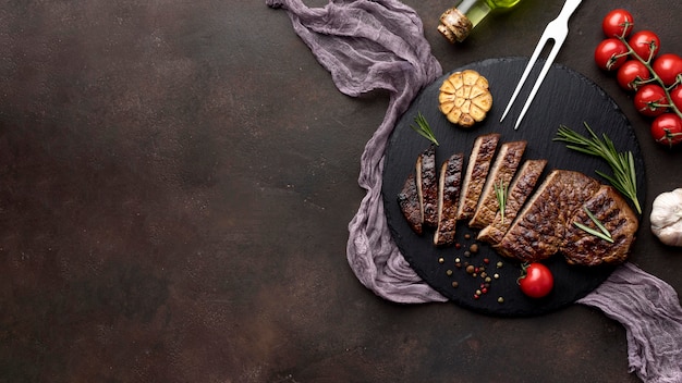 Wooden board with cooked meat and copy-space