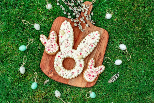 A wooden board with easter cookies on it with easter decorations on it.