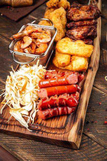 wooden board with fried sausages and potatoes