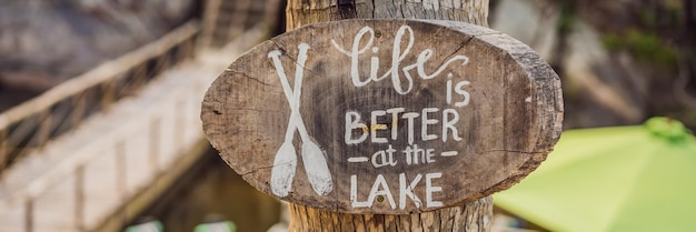 Photo wooden board with a motivational phrase life better at the lake inspiration quote banner long format