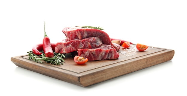 Wooden board with raw meat and fresh spices on white