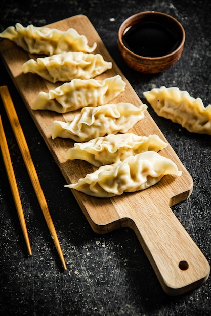 A wooden board with a variety of dumplings on it.