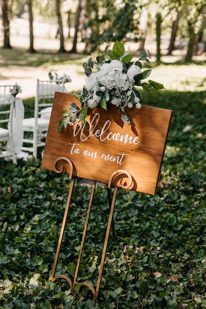 Wooden board with Welcome to our event text at a wedding ceremony