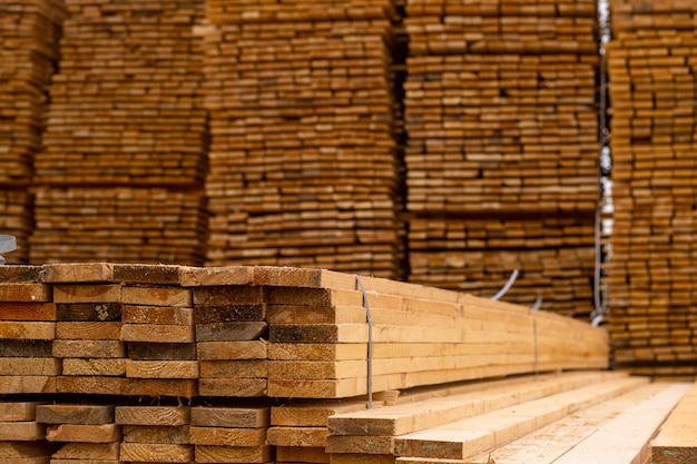 Wooden boards are stored outdoors Wooden boards lumber industrial wood timber Pine wood timber stack of natural rough wooden boards on building site