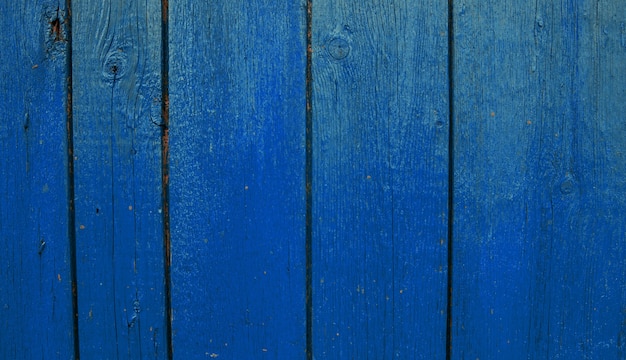 wooden boards painted in blue. rough and cracked surface. old wood and paint.