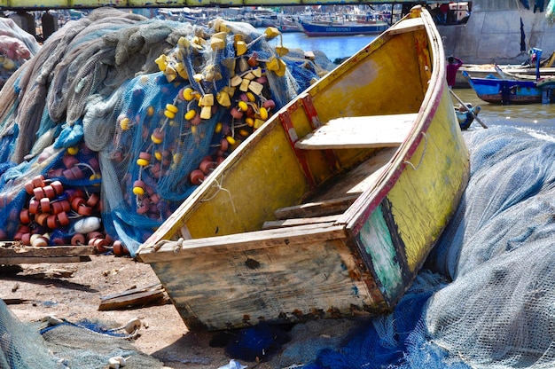 Photo wooden boat by fishing nets at harbor