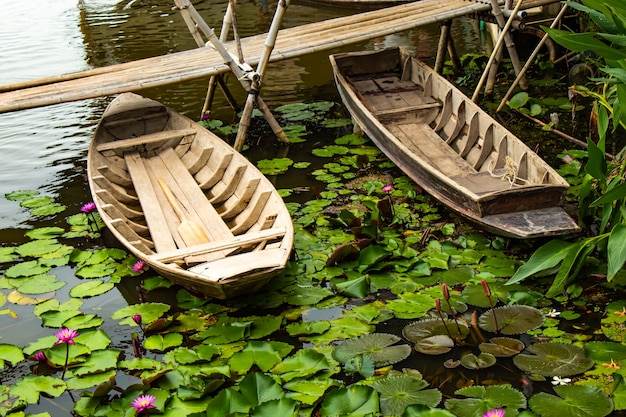 Wooden boat In the pink lotus ponds.