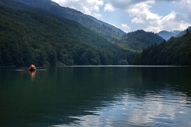 Wooden boat with tourists in a mountain lake travel