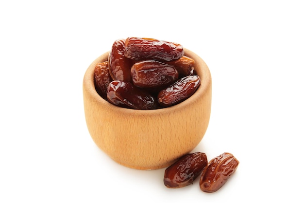 Wooden bowl of dried dates isolated on white background.