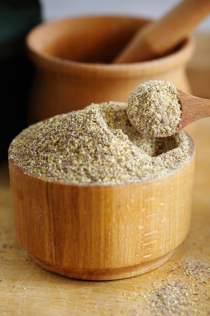 A wooden bowl full of ground flax seeds