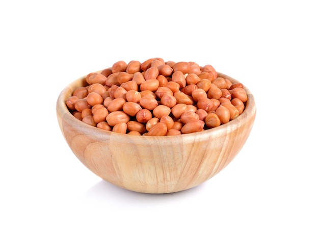 Wooden bowl of groundnuts (peanut) on white
