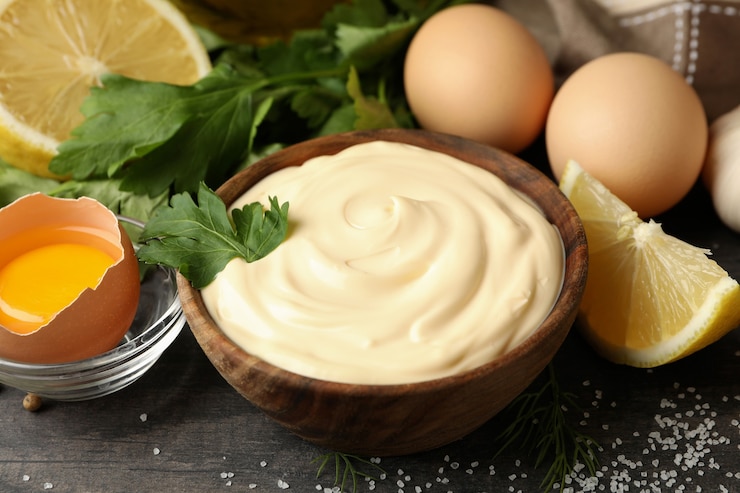 Photo wooden bowl of mayonnaise and ingredients for cooking, close up