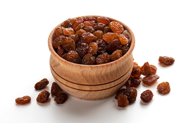 Wooden bowl of raisins isolated on white background