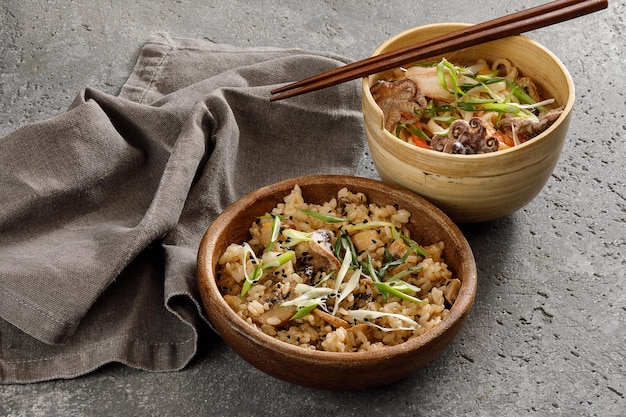 Wooden bowl of rice with vegetables served with chopsticks Traditional asian food