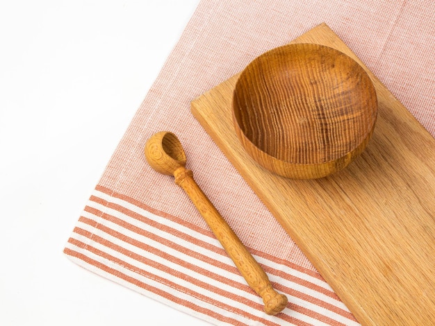 Wooden bowl and spoon with wooden cutting board on the table Top view