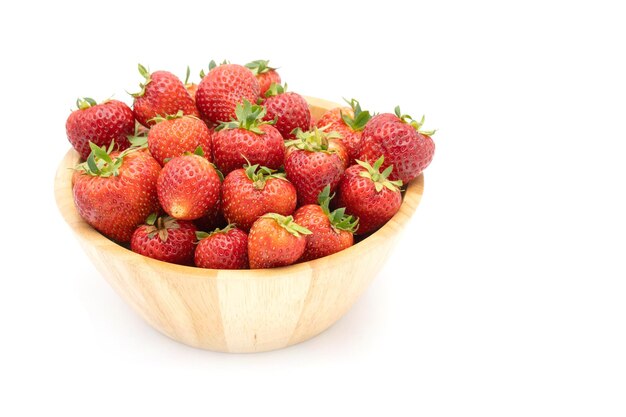 A wooden bowl of strawberries on a white background