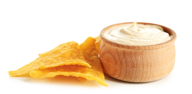 Wooden bowl of tasty hummus with chips isolated on white