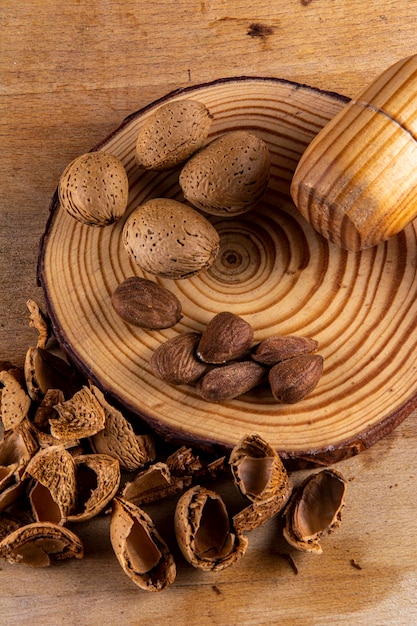 A wooden bowl with almonds and nuts on it