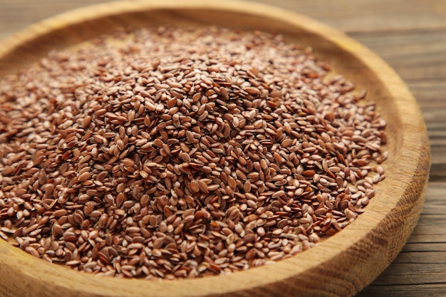 Photo wooden bowl with flax seeds on grey background