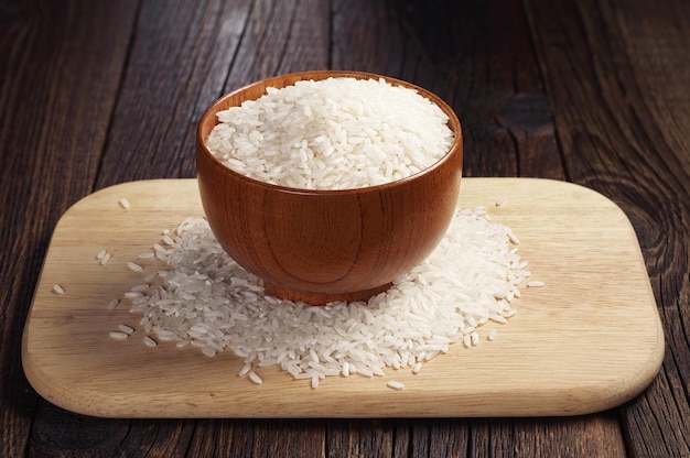 Wooden bowl with rice on a cutting board