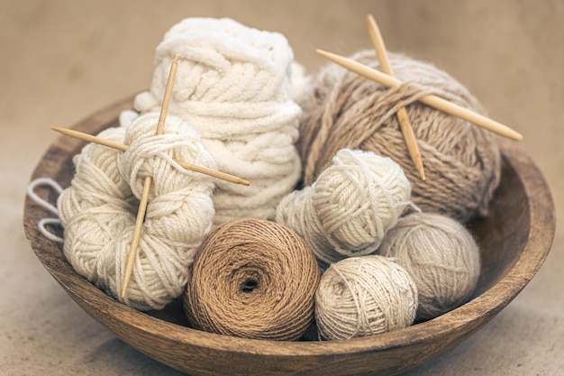 Wooden bowl with threads for knitting yarns closeup