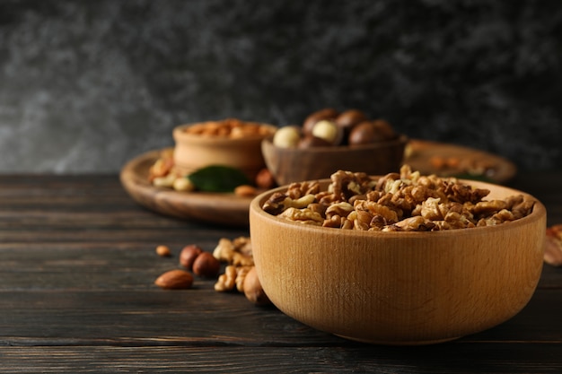 Wooden bowl with walnuts on wood