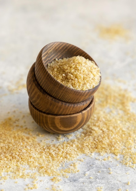 Wooden bowls with Dry uncooked bulgur wheat grain close up copy space Healthy food