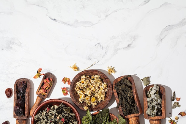 Wooden bowls with medicinal herbs mint raspberry rosehip chamomile and rose