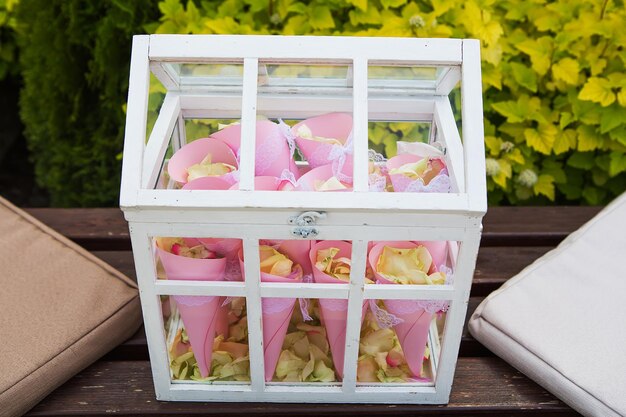 The wooden box filled with rose petals outdoors ancient style