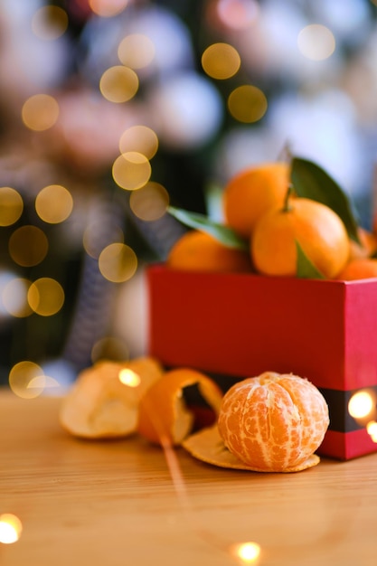 Wooden box of fresh mandarin fruits with fir branch