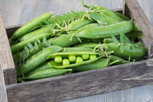 in a wooden box green peas close up