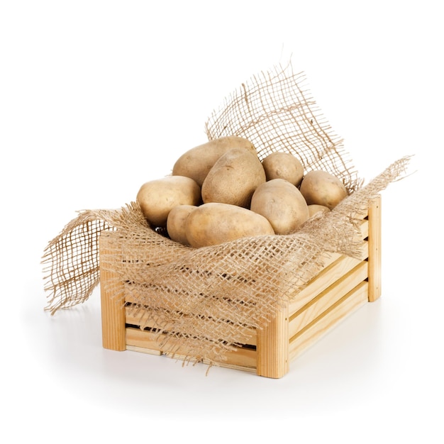 Wooden box of raw potatoes on white background