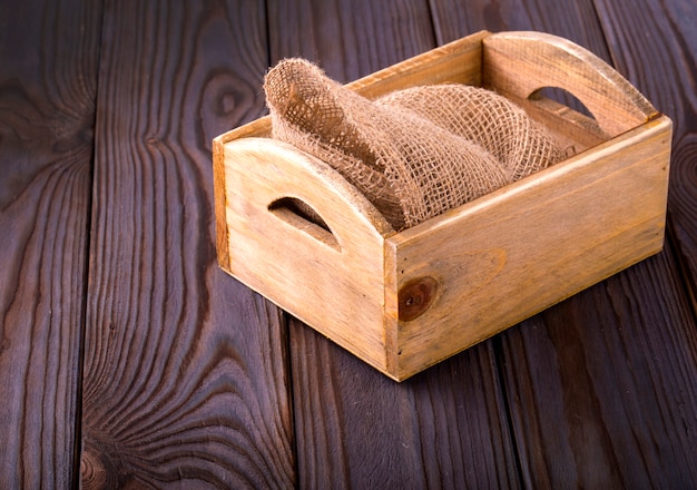 Wooden box on sack cloth on wooden background