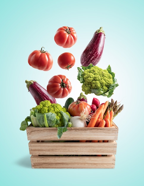 Wooden box with flying vegetables, on blue background