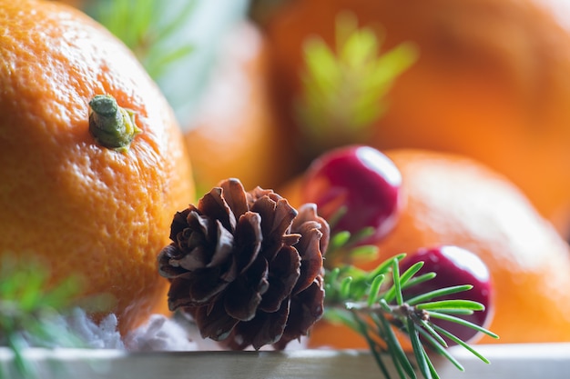 Wooden box with oranges, fir branches and pine cones. Christmas still life.