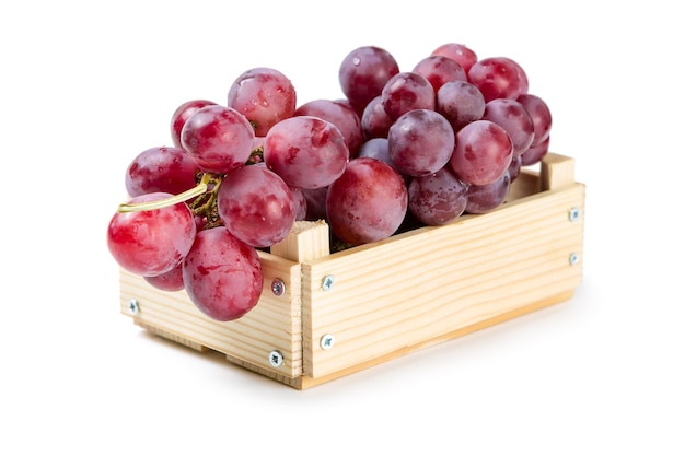 Wooden box with red grapes isolated on white background