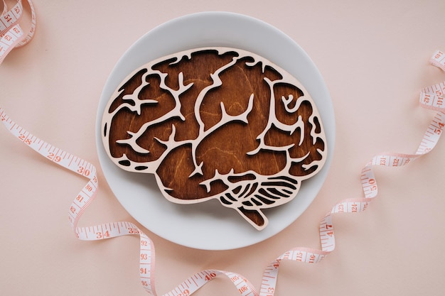 Wooden brain and tape measure on a plate Top view