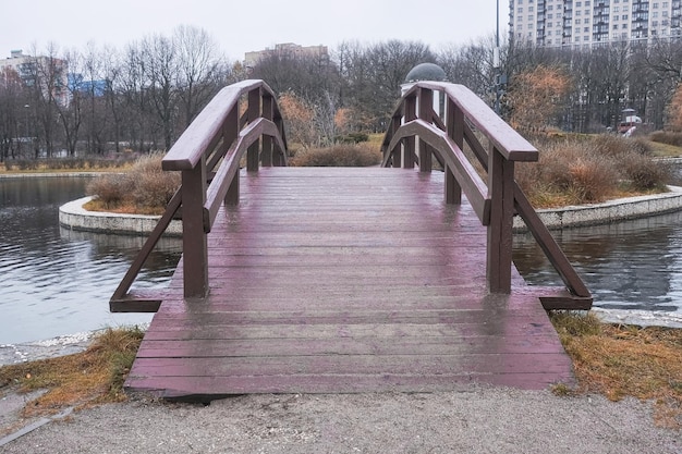 秋の公園の湖を横断する木製の橋