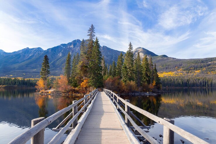 Photo wooden bridge across the lake to the little island in mountains