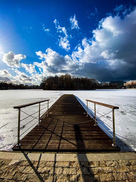 Wooden bridge against sky during winter