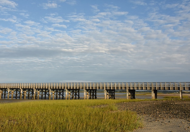 Wooden Bridge Over Bay with Marsh Grass at Low Tide