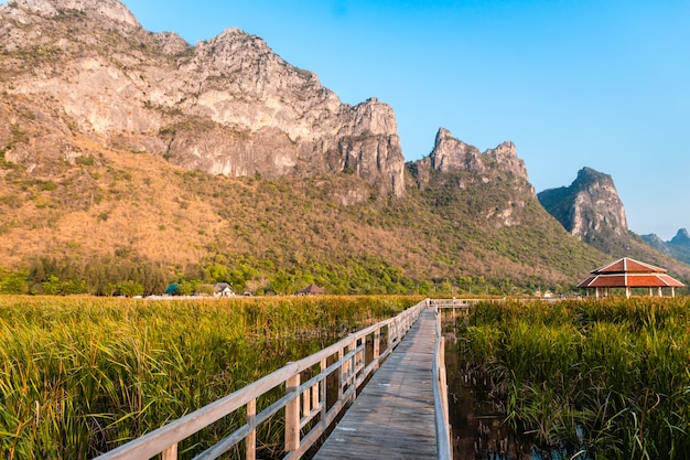 カオサムロイヨット国立公園、タイで夕暮れ時の湖と山の景観の木の橋。