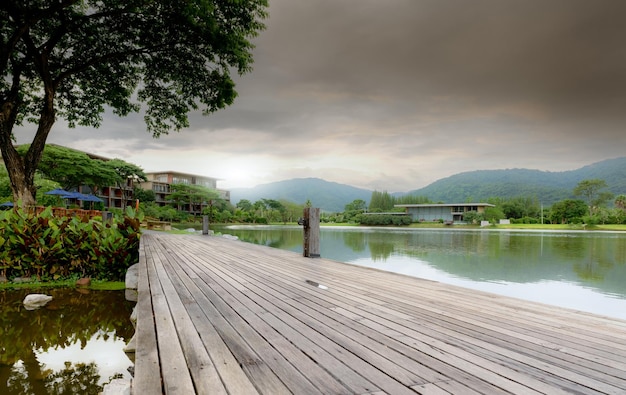 Ponte di legno sul lago in un hotel sostenibile vicino alla montagna hotel di lusso nella foresta verde