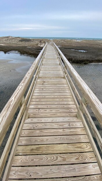 Foto ponte di legno sul mare contro il cielo