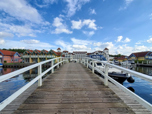 Wooden bridge with railings over water on a clear sunny cloudy day