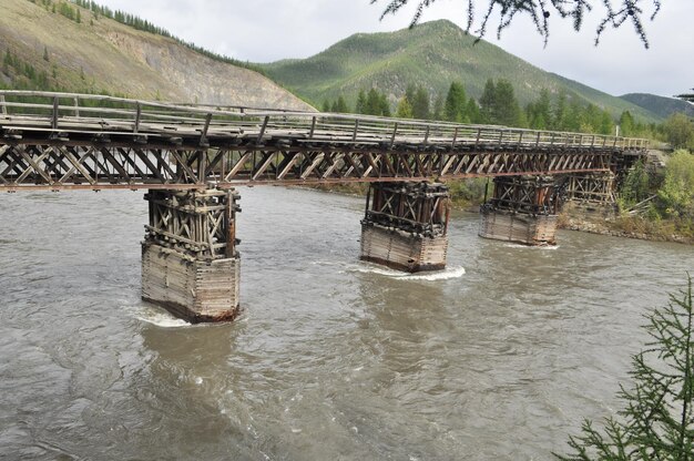 Wooden bridge in Yakutia across the mountain river