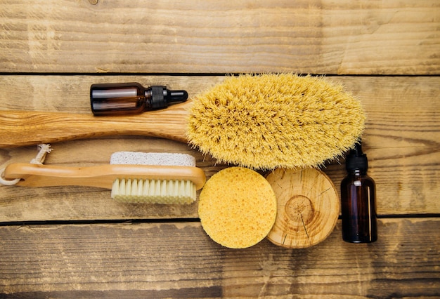 Wooden brush for dry body massage, porous sponge for the face,
jars of oil. anti-cellulite brush for body and leg massage on a
wooden background. eco-friendly material. aromatherapy and
massage.